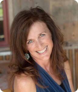 brunette woman wearing blue smiling against office