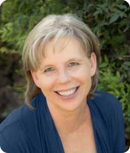 smiling woman with short grey hair smiling outdoors