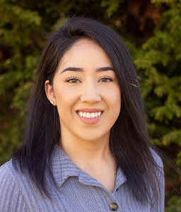 woman with short black hair smiling outside