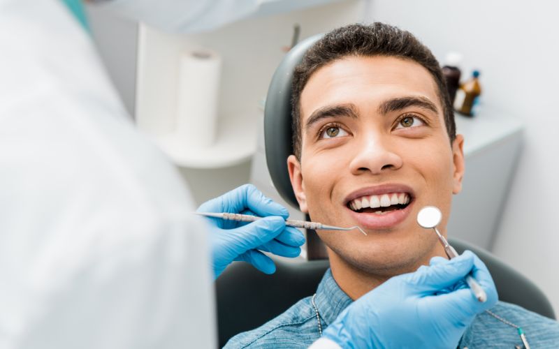 man in a dental chair looking up at the dentist smiling