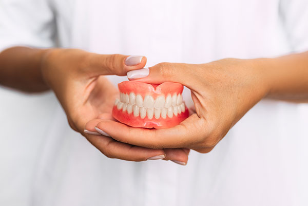 dentist holding a set of dentures