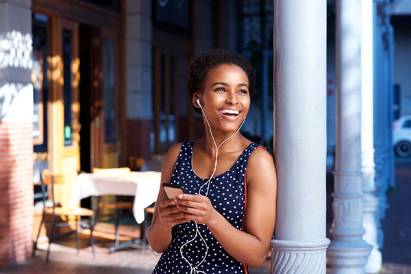 Young woman smiling with earbuds in