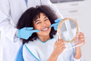 Woman,With,Mirror,At,Dentist,For,Oral
