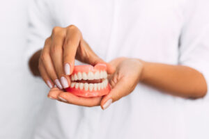 The,Dentist,Is,Holding,Dentures,In,His,Hands
