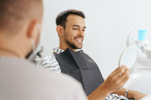 Male,Dentist,Discussing,With,Happy,Patient,After,Treatment