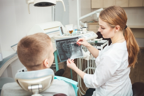 Woman,Doctor,Shows,Patient,His,X-ray,Of,Teeth