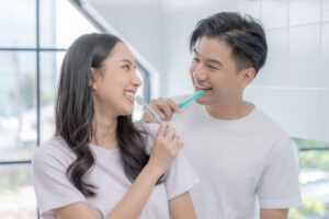 Happy,Asian,Couple,Brushing,Their,Teeth,In,The,Bathroom