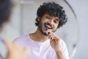 Man,Brushes,His,Teeth,In,Front,Of,A,Mirror,